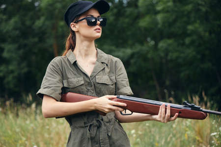 Woman on outdoor sunglasses weapon in hand hunting fresh air