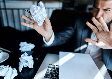 Business man in a cafe sitting at the table documents laptop crumpled paper executive lifestyle emotionsの写真素材