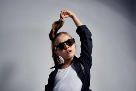 Cute schoolgirl wearing sunglasses childhood learning school light background
