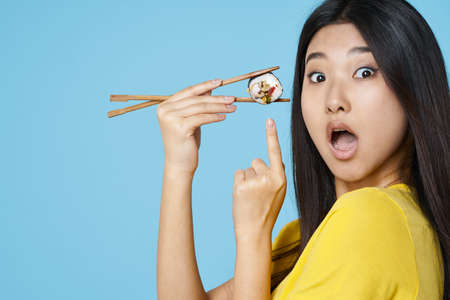 Woman with chopsticks sushi rolls seafood asianの写真素材