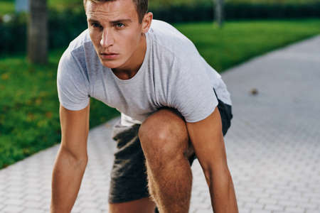sports man in sneakers shorts and a t-shirt running in the park outdoors fitness