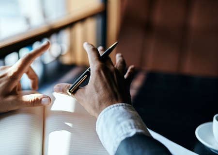 businesswoman in a cafe with a book on the table documents a cup of coffee work lifestyleの写真素材
