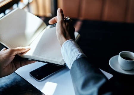 businesswoman in a cafe with a book on the table documents a cup of coffee work lifestyle