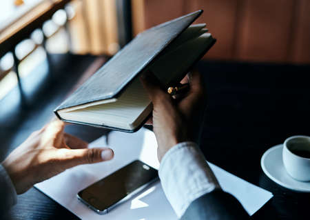 businesswoman in a cafe with a book on the table documents a cup of coffee work lifestyleの写真素材