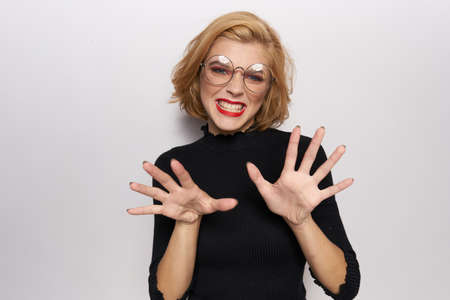 Cute blonde in glasses bright makeup black jacket cropped view light background emotionsの写真素材