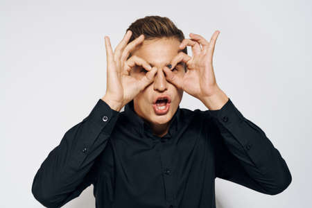 Man in black shirt lifestyle emotions modern style cropped view light backgroundの写真素材