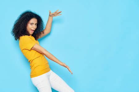 woman with black curly hair emotions gestures with hands yellow t-shirt Copy Space