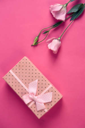 gift box and bouquet of flowers on pink background bow holidays top view