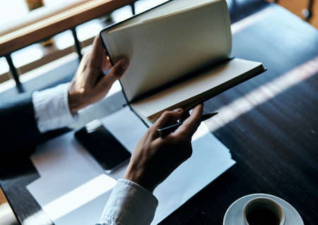 Business man in a cafe documents a cup of coffee on the table official workの写真素材