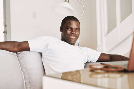 A man sits on the couch at home resting british appearance