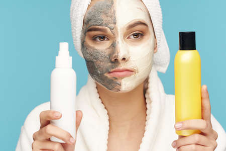 Woman with cosmetics in hands face mask clean skin dermatology