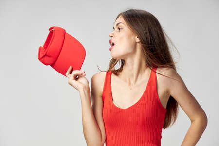 Woman looking to the side Red cap in hand T-shirt cropped viewの写真素材