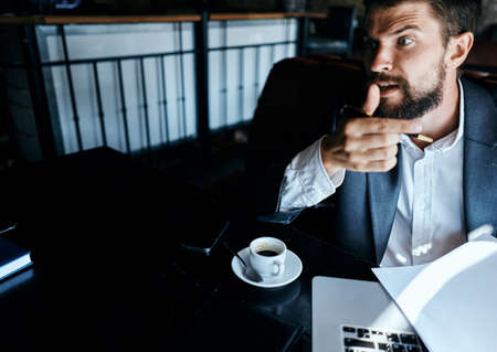 Business man in a cafe suit in front of laptop emotions official documents technologyの写真素材