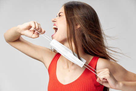 woman with a medical mask in her hands emotions look to the side open mouthの写真素材