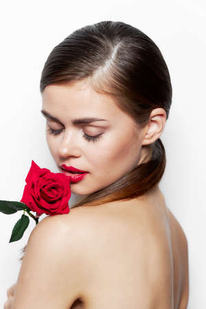 Woman with rose Closed eyes flower near lips makeupの写真素材