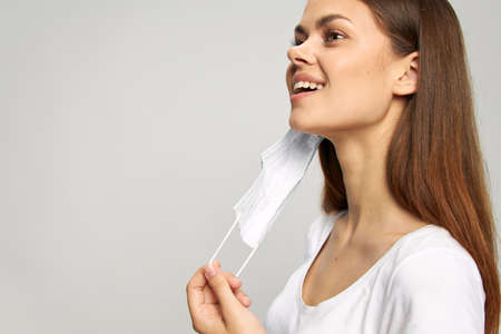 Portrait of a woman Holds a medical mask in his hand smile a look to the side