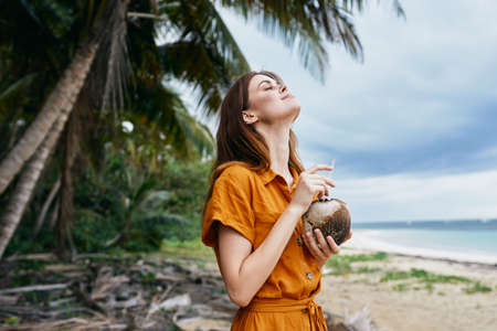 Woman Tourist With Coconut Cocktail In Hands Enjoying Fresh Air