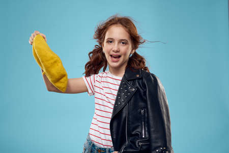 beautiful girl with a black jacket and a yellow hat on her head red hair model blue background