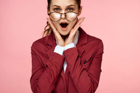 Business woman red jacket glasses executive lifestyle studio pink backgroundの写真素材