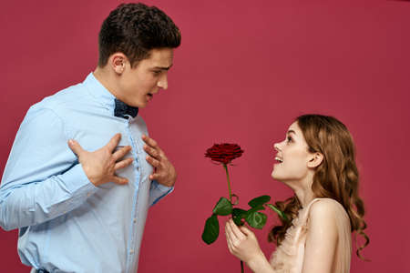 portrait of romantic couple in love with red rose on isolated background and classic suit evening dressの写真素材