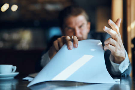 business man sitting at a table in a cafe documents work official coffee cupの写真素材