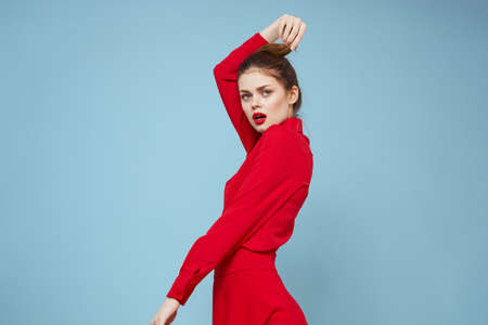 attractive woman in bright clothes on blue background gesturing with hands and red lips makeup...