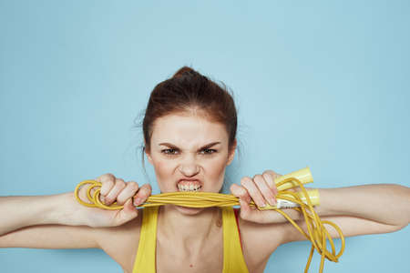 Sportive woman skipping rope exercise gym fitness blue backgroundの写真素材