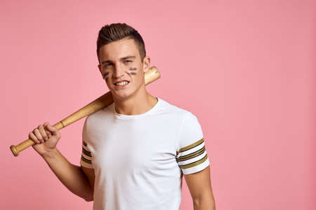 Energetic man with a bat on a pink background T-shirt face make-up black lines aggression modelの写真素材