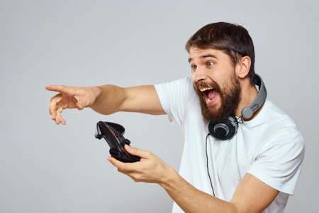 Man with gamepad headphones playing leisure technology white t-shirt light background