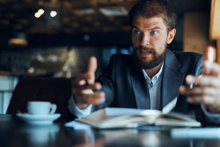 business man sitting at a table in a cafe documents work official coffee cupの写真素材