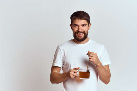 man with a cup of tea in a bag on a light background Hot drink cropped view modelの写真素材