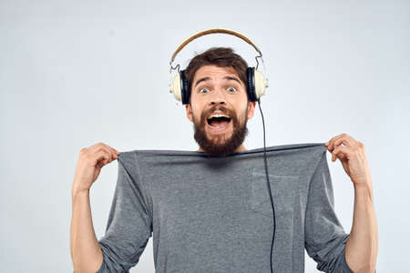 Man in headphones listens to music lifestyle modern style technology light backgroundの写真素材