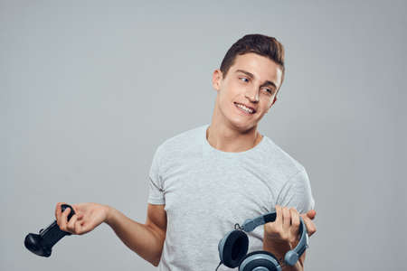 Man with headphones and joystick in hands technology entertainment video games lifestyle addiction light backgroundの写真素材