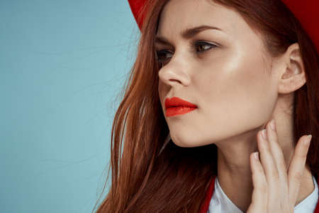 Beautiful elegant woman red lips hat on head close-up glamor blue backgroundの写真素材
