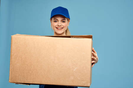 Woman working form box in hands packing delivery service blue background