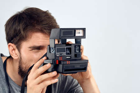 male photographer holding camera professional lens creative studio work light backgroundの写真素材