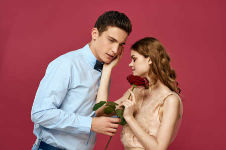 portrait of romantic couple in love with red rose on isolated background and classic suit evening dressの写真素材