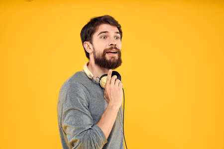 Man in headphones listens to music technology lifestyle fun people yellow background