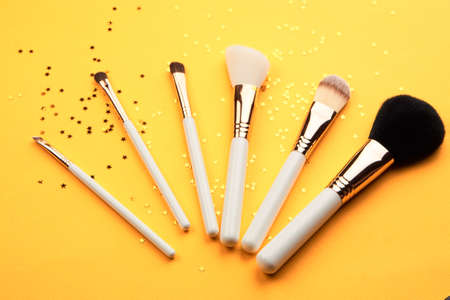 Makeup brushes with sparkles on a yellow background professional cosmeticsの写真素材