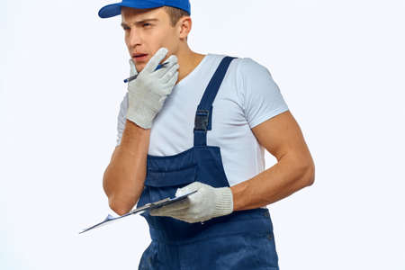 A man in a working uniform a delivery service loader light background