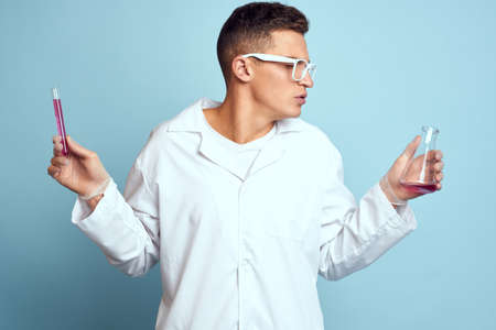 man holding flasks colorful liquid chemical laboratory model wearing glasses