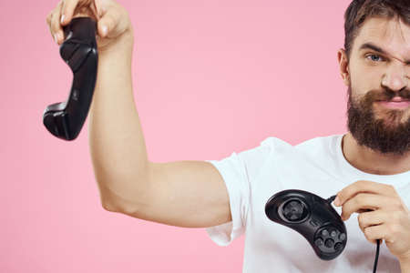 Man with two joysticks in hands fun game technology lifestyle pink background