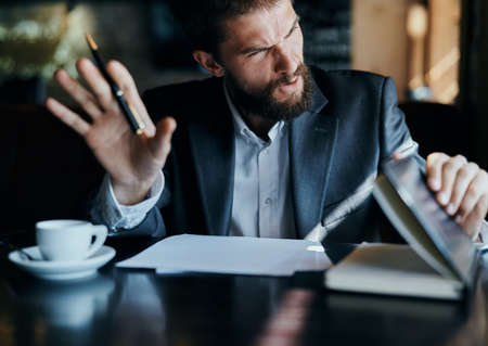 business man sitting at a table in a cafe documents work official coffee cupの写真素材