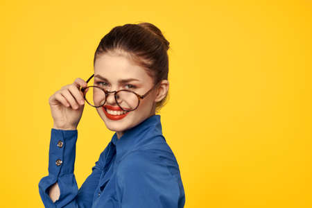 A woman in a blue shirt and glasses with bright makeup on her face is gesturing with her hands Copy Spaceの写真素材