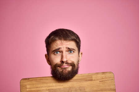 guy holding kitchen board and spatula in hand on pink background cropped viewの写真素材
