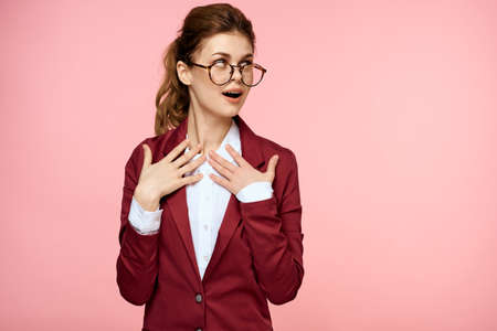 Business woman red jacket glasses executive lifestyle studio pink backgroundの写真素材