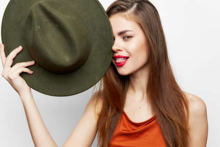 Woman holding hat Shows tongue charm model near face eveningの写真素材