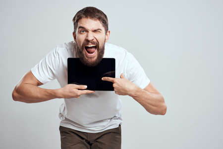 emotional man with tablet in hand touch screen new technologies light background cropped view Copy Spaceの写真素材