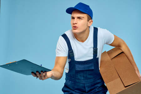 Man worker with cardboard box delivery loader lifestyle blue backgroundの写真素材