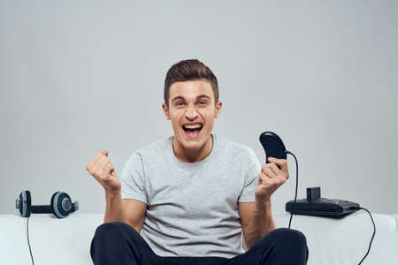 Man sitting on the couch headphones joystick games entertainment addiction leisure technology